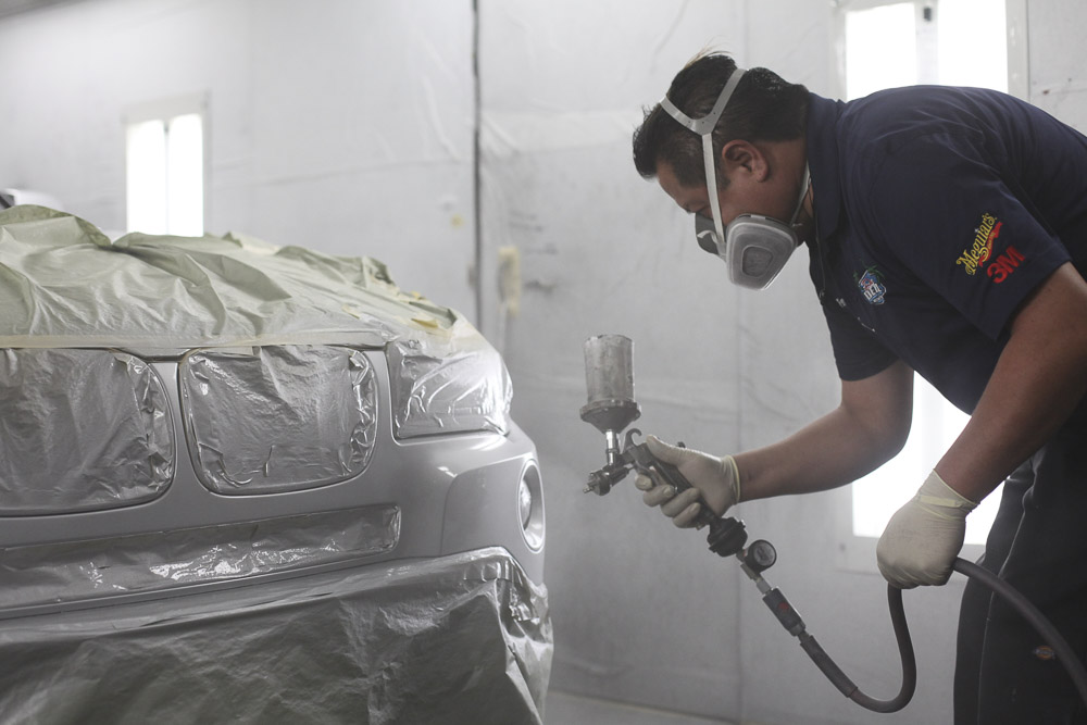 Our worker spray painting a bumper